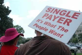 Person Holding a Sign that Says "Single Payer is What the People Want"