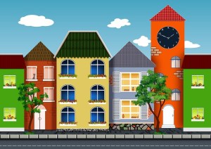 Vector image of colorful houses close together on a city street with a blue sky and a few cloud in the background.