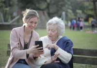 Multigenerational family members review information on a smart phone.