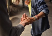 Two people holding hands, reaching out for support